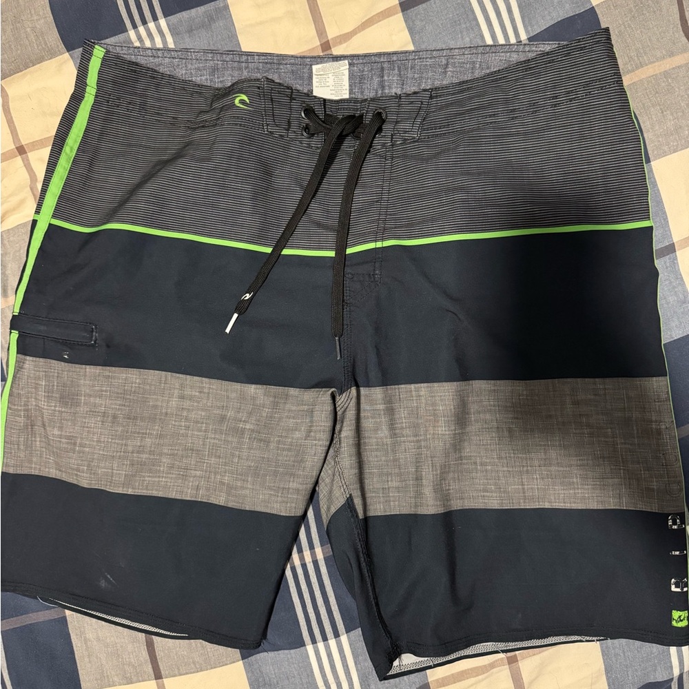 Rip Curl navy blue and gray board shorts with green accents